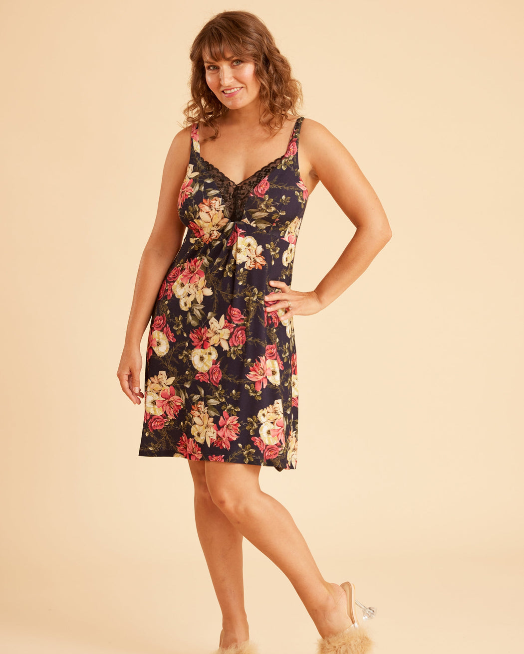 Woman wearing a floral dress on a beige background. This is the Fiske Sleepwear Set sewing pattern from Cashmerette.