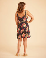 Woman wearing a floral dress on a beige background. This is the Fiske Sleepwear Set sewing pattern from Cashmerette.