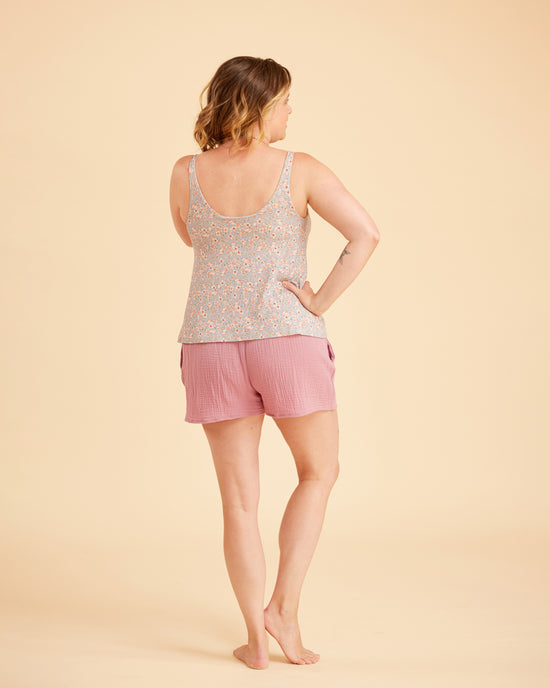 Woman wearing a patterned tank top and pink shorts on a beige background. This is the Fiske Sleepwear Set sewing pattern from Cashmerette.