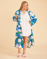 Woman wearing a blue floral robe over a white dress on a beige background. This is the Fiske Sleepwear Set sewing pattern from Cashmerette.