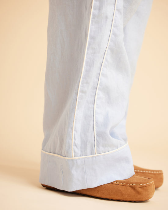 Light blue pants with white trim worn by a person on a beige background. This is the Fiske Sleepwear Set sewing pattern from Cashmerette.