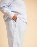 Person wearing a light blue shirt with rolled-up sleeves on a beige background. This is the Fiske Sleepwear Set sewing pattern from Cashmerette.