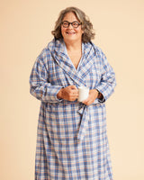 Person wearing a blue plaid robe holding a mug against a beige background. This is the Fiske Sleepwear Set sewing pattern from Cashmerette.