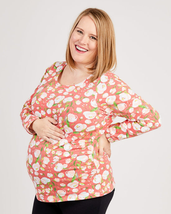 Woman wearing a pink floral dress against a white background. This t-shirt is the Brookline Maternity T-Shirt sewing pattern from Cashmerette.