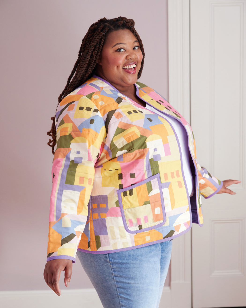 Person wearing a colorful geometric-patterned jacket against a plain background. This jacket is the Fairfax Quilted Jacket sewing pattern from "Sewing the Curve" by Jenny Rushmore.