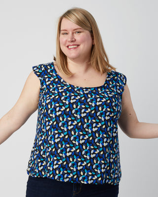 Woman wearing a blue patterned sleeveless top against a plain background. This is a pattern hack of the Springfield Top from the Pattern Hacking for Curves class.