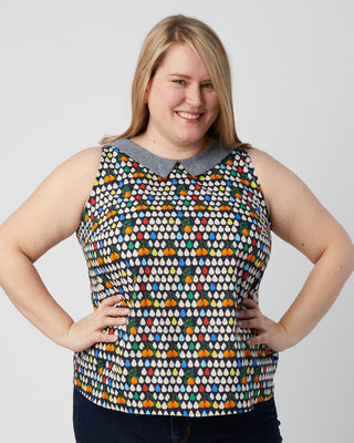 Woman wearing a sleeveless top with a colorful geometric pattern on a plain background. This is a pattern hack of the Springfield Top from the Pattern Hacking for Curves class.