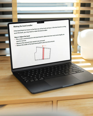 Laptop on a wooden desk with a document open on the screen