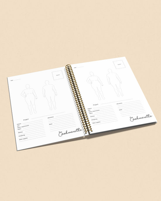 Open planner with spiral binding on a beige background