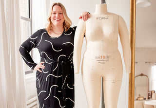 Jenny Rushmore wearing a black dress and standing next to a mannequin.