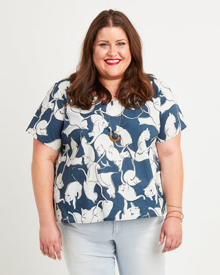 Woman wearing a blue floral blouse and light blue jeans on a white background. This is the Montrose Top sewing pattern from Cashmerette.